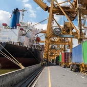 Trucks loading a cargo ship for rail-sea logistics